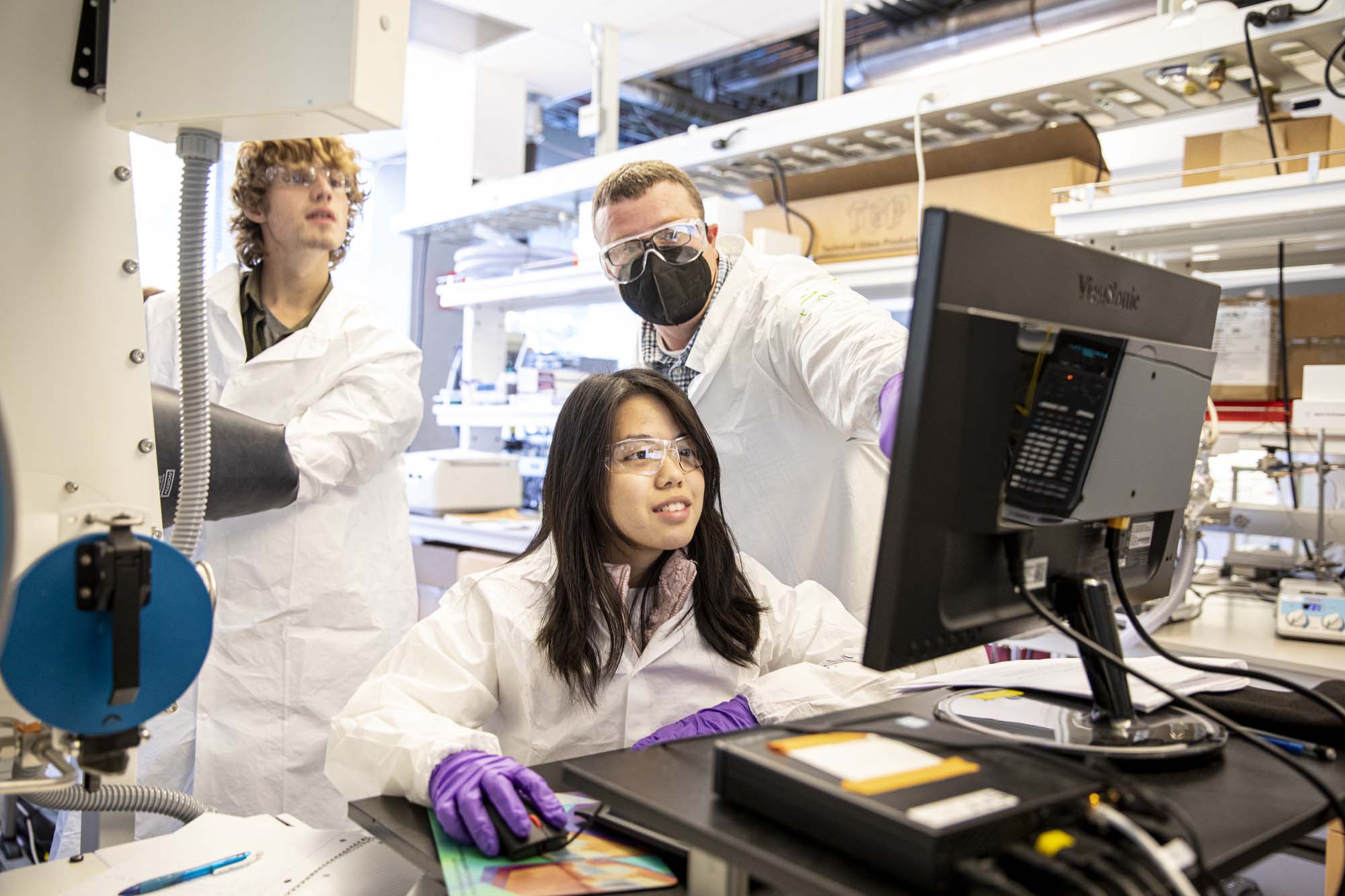 students and professor working with technical equipment