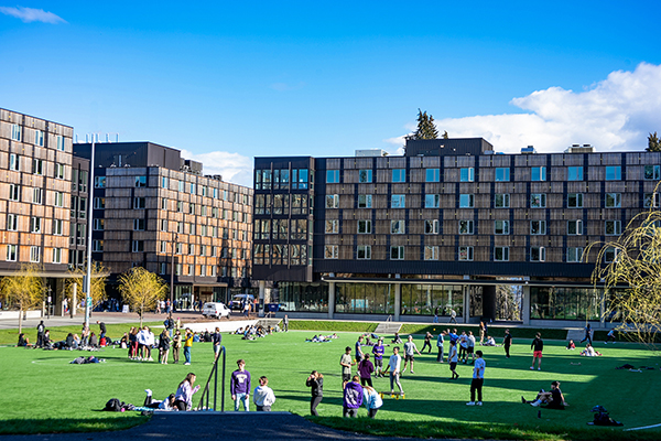 students gather on the lawn in front of residence halls
