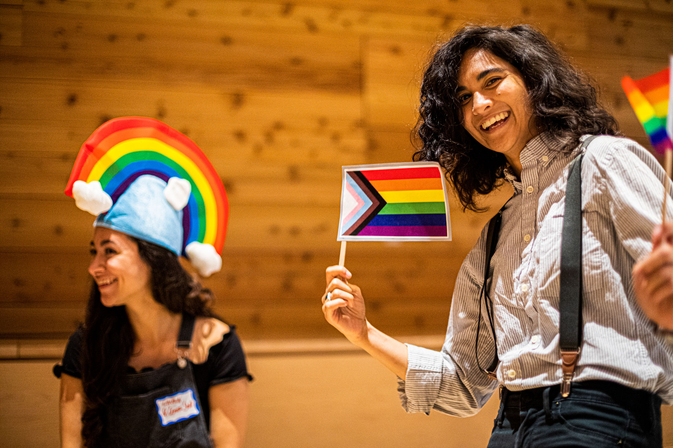 student holding small rainbow flag
